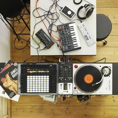 an overhead view of a dj's desk with headphones, turntables and music equipment