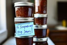 jars filled with jam sitting on top of a counter next to a sign that says, 3 ingredients for fig jam