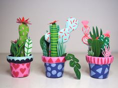 three potted cacti with different designs on them