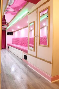 a room with pink couches and mirrors on the walls