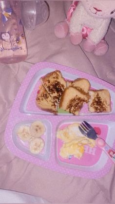 a child's tray with food on it and a stuffed animal