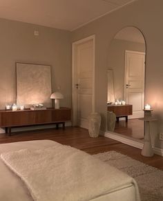 a bedroom with a bed, mirror and candles