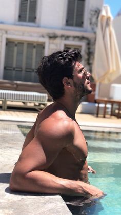 a shirtless man sitting in the middle of a swimming pool with his eyes closed