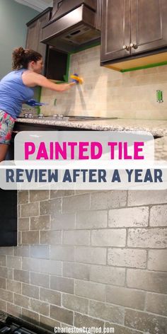 a woman is painting the kitchen cabinets in her new house, with text overlay that reads painted tile review after a year