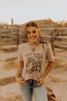 Show off your love of rodeo in our Call The Thing Rodeo Graphic Tee! This neutral-colored tee features retro text and a bucking bronco graphic. Layer your favorite turquoise and shacket to create a look for a true rodeo lover! Rodeo Tshirt Outfit, Tshirt And Jeans Photoshoot Ideas, What To Wear To A Rodeo Summer, Texas Rodeo Outfit, Rodeo Clothes, Graphic Tee Fits, Mockup Ideas, Country Graphic Tees, Rodeo Style