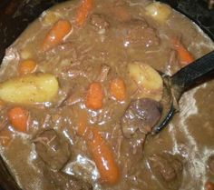 a pot full of stew with carrots, potatoes and meat in the crockpot