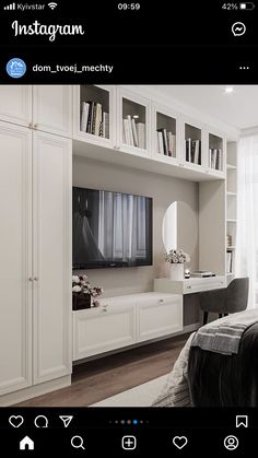 a bedroom with white furniture and bookshelves on the wall, along with a flat screen tv