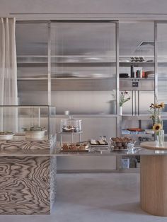 a kitchen with stainless steel cabinets and counter tops is shown in this image, there are flowers on the table