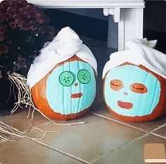 two pumpkins with faces painted on them