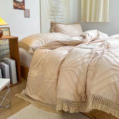 an unmade bed in a bedroom with two nightstands and a lamp next to it