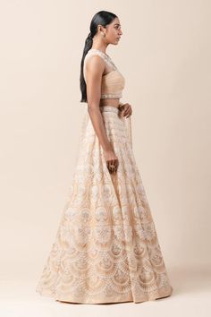 Peach lehenga with aari threadwork and highlighted with pearls-sequin. Comes with fluted blouse enhanced with French knots-pearl work and embroidered dupatta. 
Component: 3
Embroidered
Neckline: Round
Sleeve Length: Sleeveless
Fabric: Sheer Silk, Net, Chiffon
Color: Peach
Sheer panel
Cutout back - Aza Fashions Beige Cutdana Anarkali Set For Reception, Reception Beige Anarkali Set With Cutdana, Reception Beige Cutdana Anarkali Set, Traditional Drape Lehenga With Chikankari Embroidery For Reception, Anarkali Style Beige Choli For Reception, Wedding Beige Choli With Cutdana, Bollywood Beige Lehenga With Cutdana, Festive Chikankari Embroidery Lehenga For Reception, Bollywood Style Beige Lehenga With Cutdana