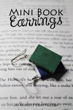 the book earrings are green and blue with silver hooks on each earring, which is attached to an open book page