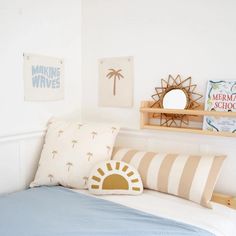 there is a bed with two pillows on the headboard and a mirror above it