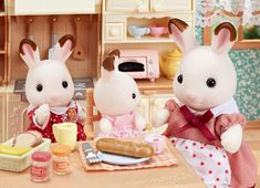 two stuffed animals sitting at a table with food