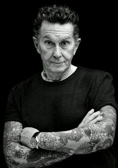 an older man with tattoos on his arms