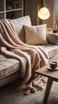 a living room with a couch, coffee table and blanket on it's back