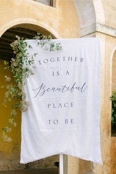 a white towel with the words together is a beautiful place to be hanging on a pole