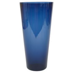 a tall blue glass vase sitting on top of a table