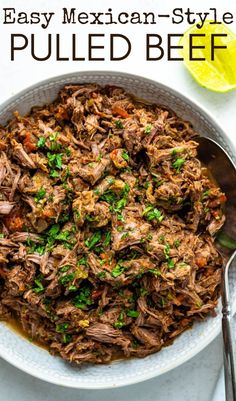 a bowl filled with pulled beef and garnished with cilantro on top