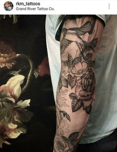 a man's arm with flowers and birds on it