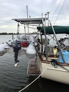 a sailboat tied up to the dock with life vests hanging off it's sides