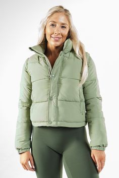 Our Vitality Convertible Puffer is designed to keep you warm without the extra bulk. This jacket is the perfect choice for anyone seeking a balance between warmth and mobility in their outerwear. Functional Green Puffer Jacket For Fall, Versatile Puffer Outerwear For Outdoor, Versatile Fitted Outerwear For Outdoor, Functional Puffer Outerwear In Solid Color, Functional Solid Puffer Outerwear, Versatile Fitted Outdoor Outerwear, Versatile Puffer Outerwear For Cold Weather, Functional Green Puffer Jacket, Green Puffer Jacket With Padded Collar For Cold Weather