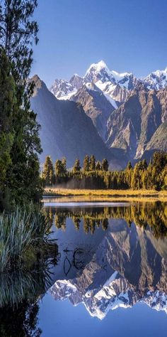 the mountains are reflected in the still water