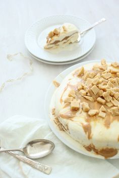 there is a cake on the table with peanut butter toppings and a spoon next to it