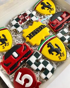 decorated cookies in a box with ferrari emblems and numbers on the top one is red, white, and green