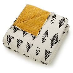 a quilted blanket with black and white designs on it, folded to show the front