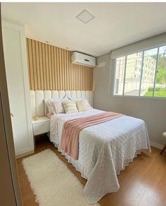 a white bed sitting next to a window in a bedroom