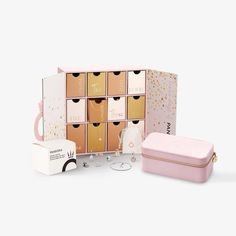 a pink and gold box with several boxes in it next to some other items on the floor