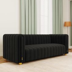 a black couch sitting on top of a white rug