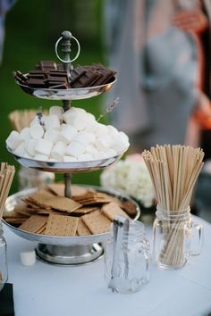 there is a three tiered tray with marshmallows and graham crackers on it