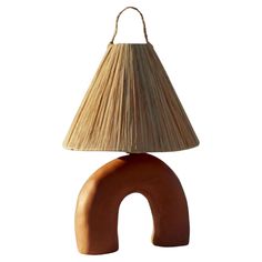 a lamp that is sitting on top of a wooden base with a light shade over it