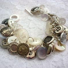 a close up of a bracelet on a table with buttons and other things in it