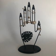 a black metal sculpture with rings on it's fingers