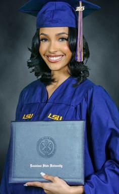 a woman wearing a blue graduation gown and holding a diploma