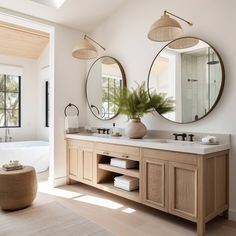 a bathroom with two sinks, mirrors and a bathtub in the middle of it