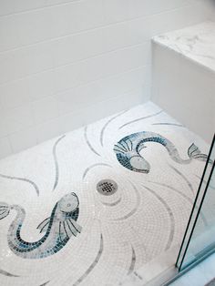 a bathroom with a glass shower door and tiled floor