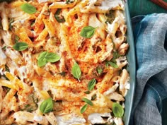 a casserole dish with chicken, cheese and spinach on a blue plate