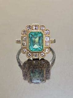 DeKara Designs Classic Handmade Art Deco Oval Emerald and Diamond Ring. Metal- 14K Yellow Gold, .583 Stones- GIA Certified Elongated Octagonal Colombian Emerald 1.99 Carats, 14 Single Cut Round Diamonds G-H Color VS2-SI1 Clarity 0.52 Carats, 6 Square Baguette Diamonds G-H Color VS2-SI1 Clarity 0.50 Carats. GIA Report Number 2225040369 An amazing entirely handmade GIA Certified Elongated Colombian Emerald and Antique Diamond Engagement Ring Created in 14K Yellow Gold. There is a beautiful blue gr Art Deco Green Diamond Ring Hallmarked, Gia Certified Oval Emerald Ring In Art Deco Style, Yellow Gold Radiant Cut Emerald Wedding Ring, Yellow Gold Radiant Cut Emerald Ring For Wedding, Gia Certified Emerald Cut Art Deco Rings, Vintage Gia Certified Gold Emerald Ring, Gold Art Deco Ring With Center Stone, Heirloom Green Diamond Ring With Bezel Setting, Vintage Gia Certified Baguette Cut Jewelry