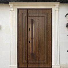 a wooden door on the side of a white building