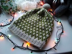 a knitted hat sitting on top of a table next to stuffed animals and lights