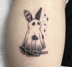 a woman's thigh with a tattoo of a rabbit in a dress on it