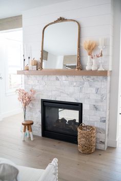 a living room with a fireplace and mirror