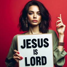 a woman holding a sign that says jesus is lord