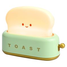 a toaster shaped like a face with red eyes and the word toast on it