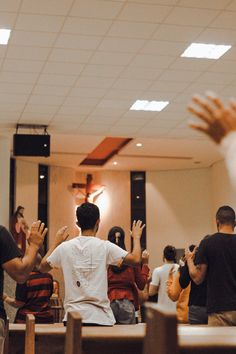 several people in a church with their hands up