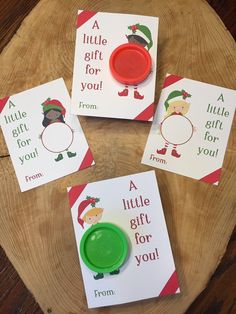 three little christmas cards and a green button on a wood slice with the words a little gift for you